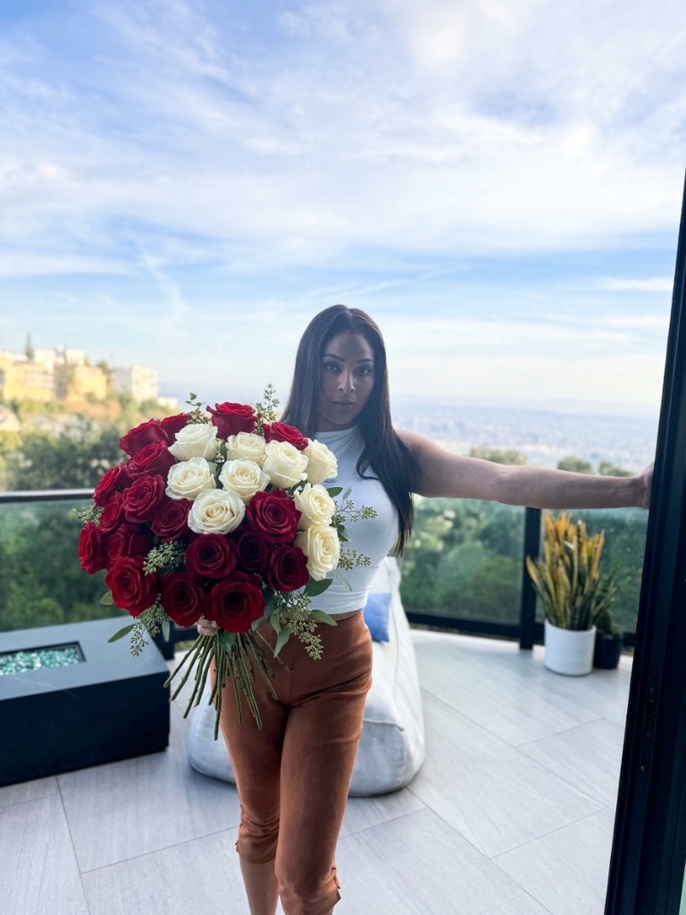 Lifestyle — woman holding luxury bouquet on LA balcony